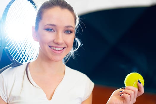 Close up portrait of a young attractive woman tennis player holding tennis racket