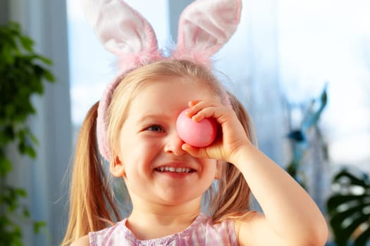 Happy little girl just painted an egg for Easter