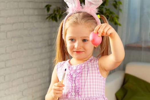 Happy little girl just painted an egg for Easter