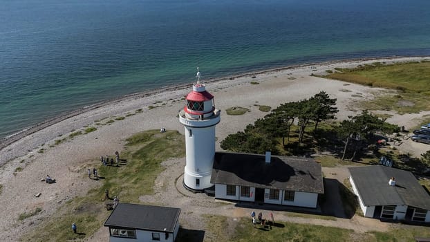 Djursland,Denmark,31-08-2024: people anjoy the summer at the white round lighthouse Sletterhage on the Helganaes peninsula ,drone photo