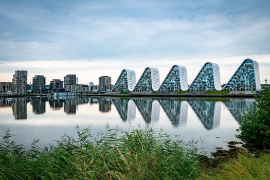 The wave boelgen iconic modern apartments in Vejle, Denmark with reflection in the water