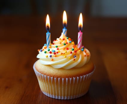 Birthday cupcake with candles and colorful frosting, topped with sprinkles, perfect for a celebration