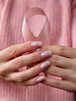 Pink October Breast Cancer Awareness month, woman hand with pink Ribbon in hospital for support people life and illness. Vertical