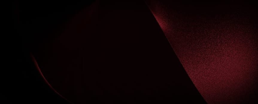 A close-up of a red fabric, the light subtly highlights its texture and creates an abstract, almost artistic, composition.
