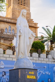 The statue of Saint Maria in the square of Nha Trang Cathedral or Stone Church or Christ the King Cathedral in Asia in summer. Nha Trang, Vietnam - August 22, 2024
