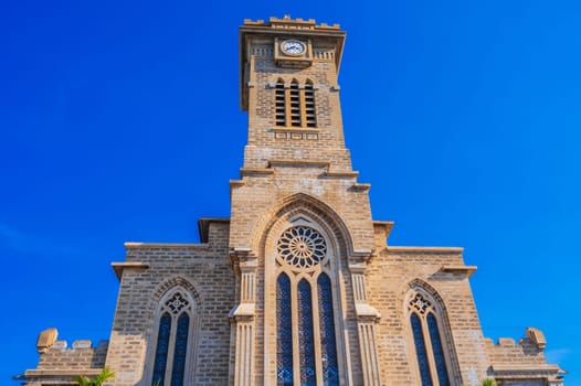 Clock Tower on Nha Trang Cathedral or Stone Church or Christ the King Cathedral in Vietnam against a blue sky