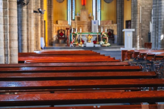 Wooden benches inside the Catholic Cathedral in Nha Trang in Vietnam in Asia