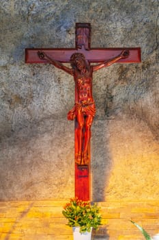 Wooden cross crucifixion with Jesus Christ God in a Catholic church