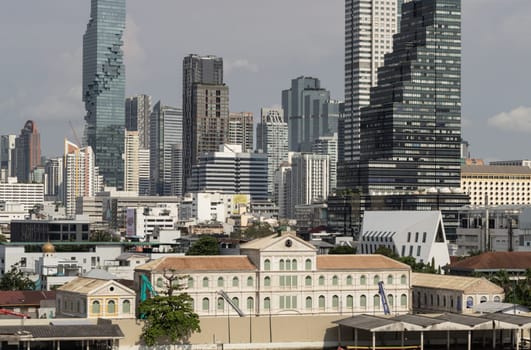 Bangkok, Thailand - 28 Sep, 2024 - Exterior view of The old customs house Or Old bang rak fire station building with Skyscrapers background at Bangkok city. Architectural View of Old and New Buildings in Contrasting Classical and Modern Designs, Space for text, Selective focus.