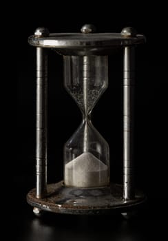 Silver hourglass (Sandglass) on Dark background. Concept of hope and Value of time. Space for text, Selective focus.