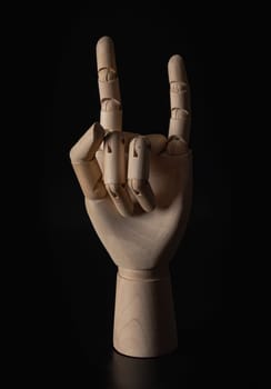Wooden hand of mannequins showing Index finger and little finger up sign on dark background. "I Love You" or "Devil Horn" gesture concept, Wooden hand puppet, Showing, Symbol, Banner design, Gesture and sign, Space for text, Selective focus.