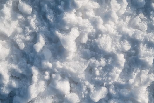 Background with texture of white snow on a snowdrift on a cold winter day