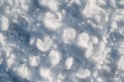 Background with texture of white snow on a snowdrift on a cold winter day