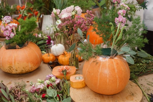 Flower arrangement in a pumpkin, autumn interior decor. Creating handmade autumn decor