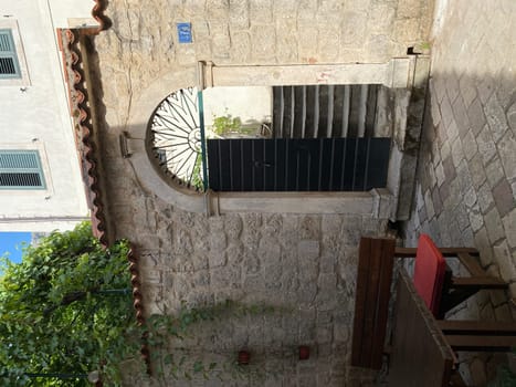 Old wooden arched door in stone wall, vertical photo
