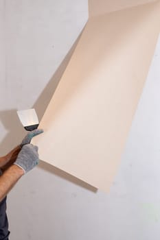 woman tears off Wallpaper, removing Wallpaper from the wall with a spatula, the process of updating the wall room repair.