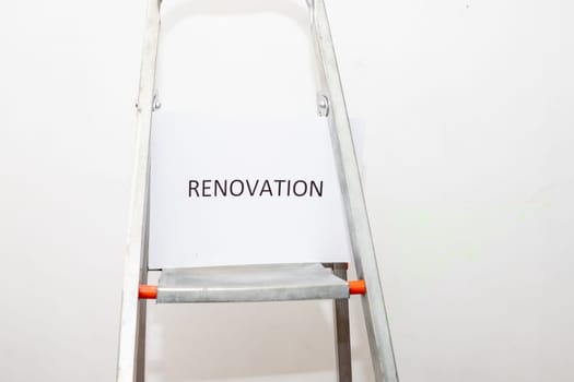Stepladder and painting tools near wall in empty room