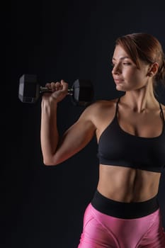 sporty girl doing exercises with dumbbells on black background, sport concept, healthy and beautiful body