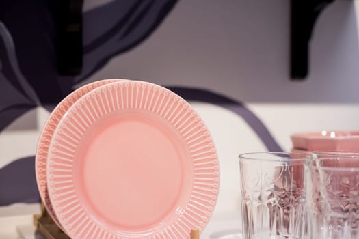 Commercial white plates and bowls stacked with crystal wine glasses