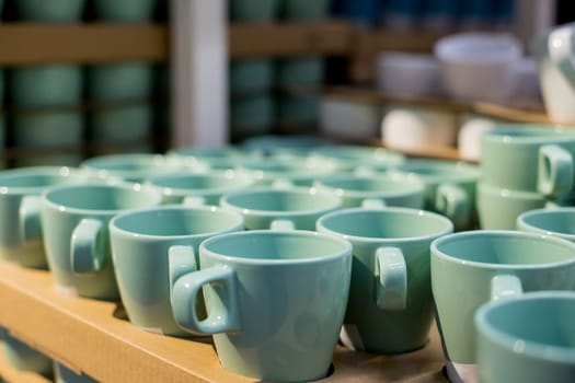 Ceramic cups on the wooden shelves in the store