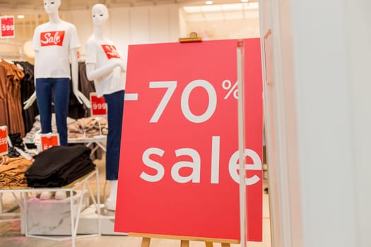Sale up to 70 percent red sign. Red circle with sale up to seventy percent inscription sticked on the store window