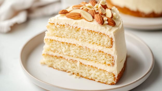A delectable slice of almond cake showcases light, fluffy layers filled with creamy frosting. Topped with crunchy almonds, it offers a delightful treat perfect for any occasion.