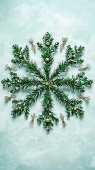 Christmas snowflake made of pine branches with ornaments on light green background. Holiday decoration concept.