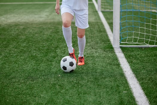 And the soccer player in the uniform and red clothes controlling the soccer ball on the Green Field. football training