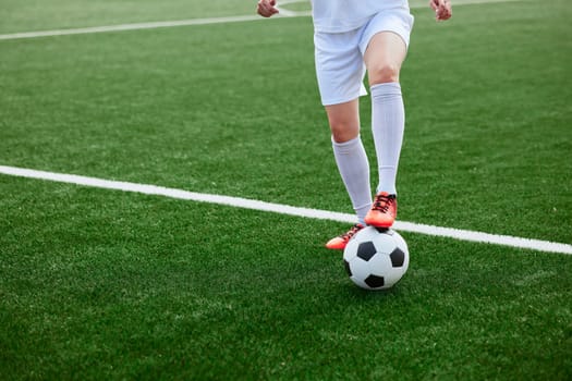 And the soccer player in the uniform and red clothes controlling the soccer ball on the Green Field. football training