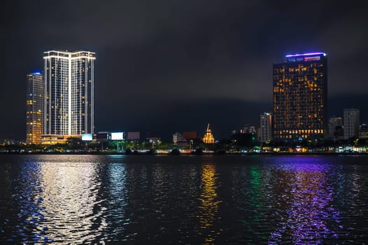 Night panorama of Da Nang city with the Han River embankment and hotels skyscrapers on the shore at night in Vietnam