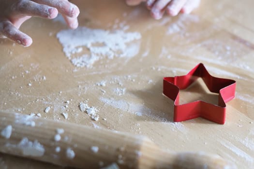Christmas food background with cookies red molds. flour and hands.