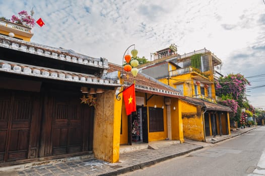 Streets with traditional ancient yellow houses in the old town in Hoi An city in Vietnam at summer day