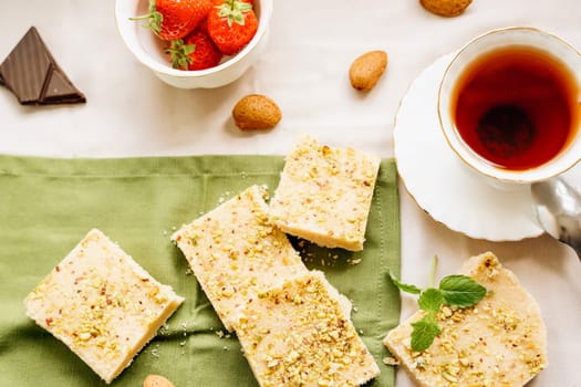tea, milk, cakes, chocolate pieces, halva on the table