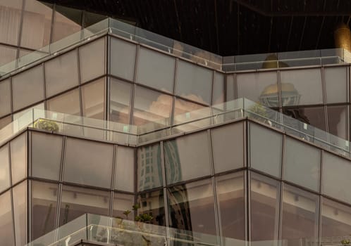 Bangkok, Thailand - 28 Sep, 2024 - Architecture exterior of Modern building with many glass wall reflecting with the sky background at afternoon. Copy space, Selective focus.