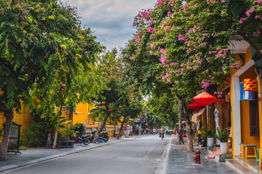 Beautiful ancient asian streets in the old town of Hoi An city with historic houses and green trees. Hoi An, Vietnam - September 12, 2024