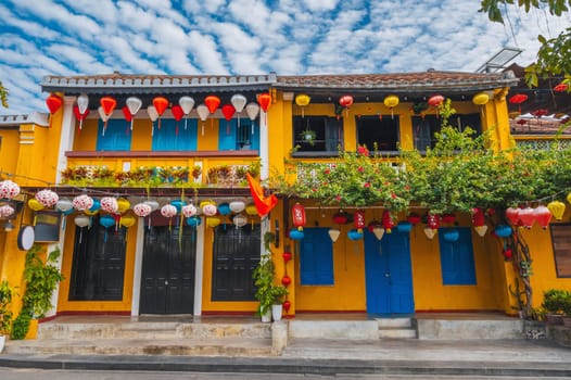 facade of an ancient Asian house decorated with colorful hanging Chinese lanterns for a holiday in the old town in Hoi An in Vietnam