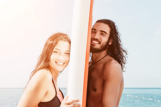 Woman man sea sup. Close up portrait of beautiful young caucasian woman with black hair and freckles looking at camera and smiling. Cute woman portrait in a pink bikini posing on sup board in the sea