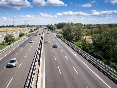 Piacenza, Italy - September 2017 cars and truck on motorway a1 autostrada del sole , daylight, serene sky with clouds.