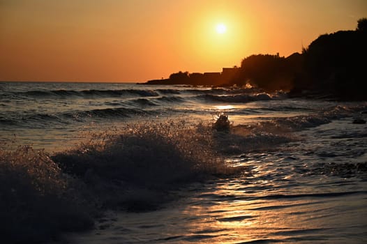 Beautiful colourful sunset on the beach with the sea and waves. A concept for travel, holidays and summer holidays by the sea. Greece - Corfu island - Agios Georgios