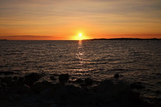 Beautiful colourful sunset on the beach with the sea and waves. A concept for travel, holidays and summer holidays by the sea. Greece - Corfu island - Agios Georgios