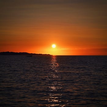 Beautiful colourful sunset on the beach with the sea and waves. A concept for travel, holidays and summer holidays by the sea. Greece - Corfu island - Agios Georgios