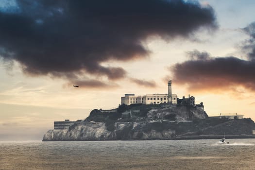 Capture the eerie allure of Alcatraz Island from an entirely new perspective. This stunning aerial shot includes a helicopter in the frame, adding a dynamic layer to the historic and notorious prison island. The photo offers a unique viewpoint, marrying technology and history in one compelling image.