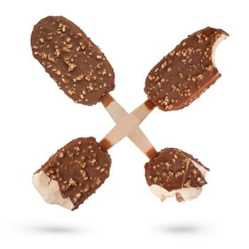 Ice cream on a stick in chocolate glaze with pieces of nuts. Four servings of ice cream of varying bite levels are folded into the letter X on a white isolated background. High quality photo