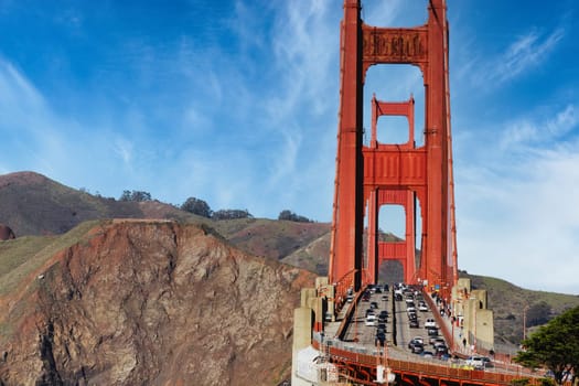 A dynamic photograph that captures the bustling traffic on San Francisco's iconic Golden Gate Bridge. This high-energy scene illustrates the constant flow of life and movement, showcasing the essential role this landmark plays in the city's daily transportation. Perfect for any projects that require a representation of urban life, transportation, or iconic American landmarks