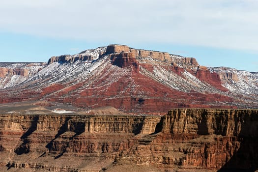 Immerse yourself in the winter magic of the Grand Canyon with this high-resolution photograph featuring snow-draped peaks under a light blue sky. The image captures a rare moment when the iconic red-rock formations are transformed into a winter wonderland, offering a different yet equally stunning perspective on this natural marvel. The light blue sky complements the snowy scenery, adding a tranquil quality to the dramatic landscape. Ideal for bringing a touch of serene beauty to your home, office, or digital project