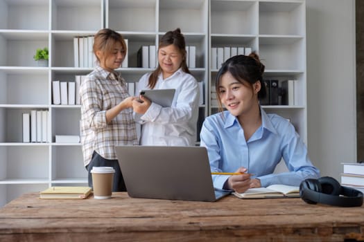 College students using laptop while sitting at table. Group study for school assignment