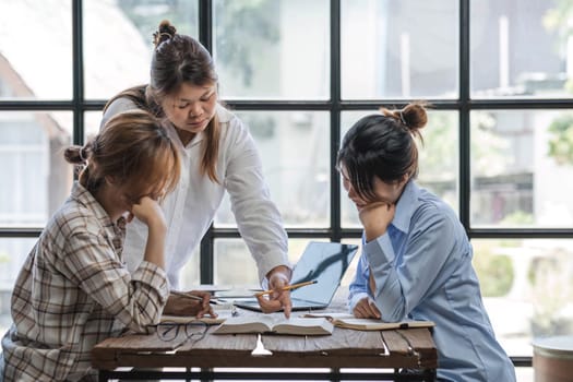 College students using laptop while sitting at table. Group study for school assignment