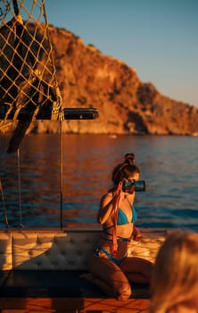 A breathtakingly serene view of the sunset showcases a woman capturing the stunning beauty of the sea