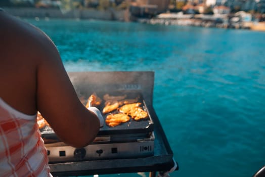 A lively and vibrant scene of grilling delicious fish outdoors by the tranquil, serene waterfront area