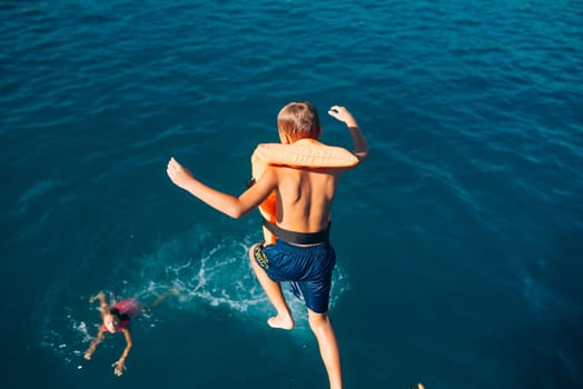 Children are happily enjoying a funfilled summer day by joyfully jumping into the cool water with excitement